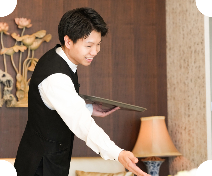 笑顔で料理を運ぶホールスタッフ